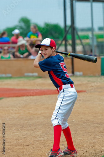 Cute baseball player holding a bat.