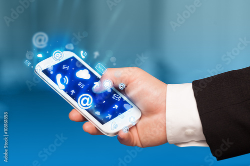 Wallpaper Mural Business man holding smart phone with media icons Torontodigital.ca