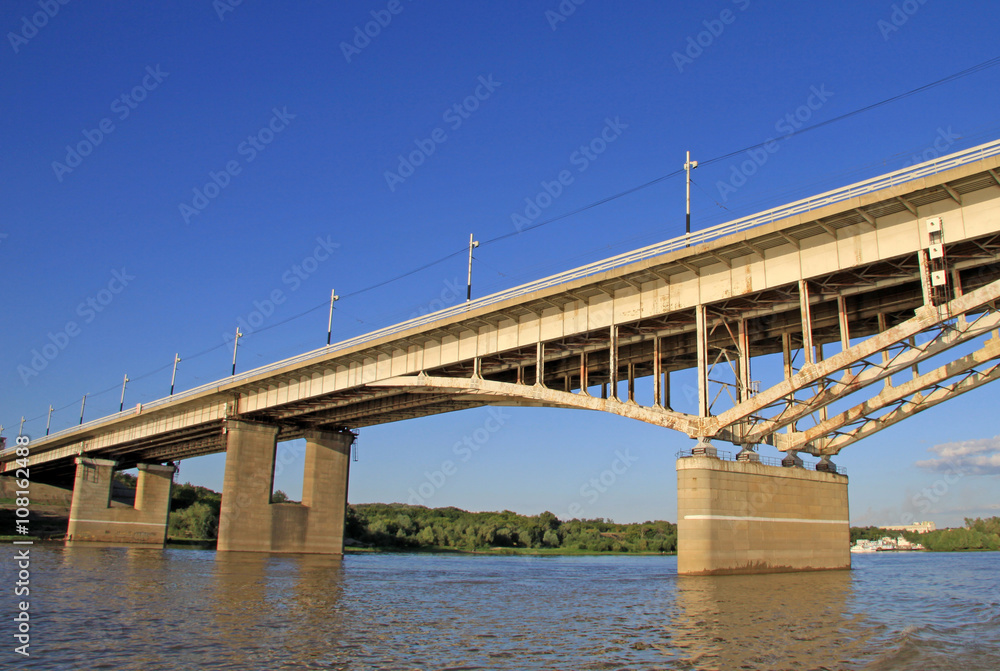 OMSK, RUSSIA - JUNE 21, 2010: Bridge named after the 60th anniversary of the Komsomol over the Irtysh River in Omsk, Russia OMSK, RUSSIA - JUNE 21, 2010: Bridge named after the 60th anniversary of the Komsomol over the Irtysh River in Omsk, Russia
