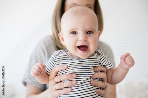 Mother holding her smiling baby girl photo