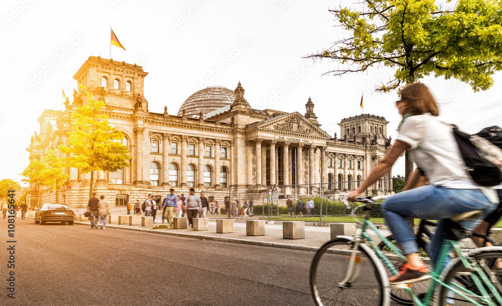 Fototapeta premium Życie miejskie w Berlinie z Reichstagiem o zachodzie słońca w lecie, Niemcy
