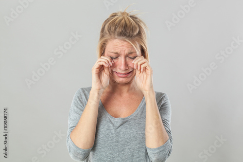 complaining young blond woman crying with big tears expressing sadness