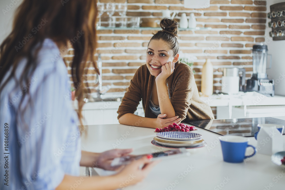 Caucasian women talking in kitchen Caucasian women talking in kitchen
