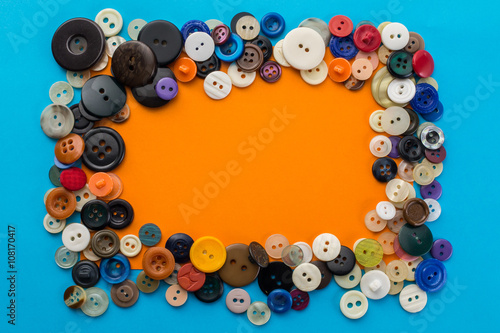 buttons and orange sheet of paper on a blue background