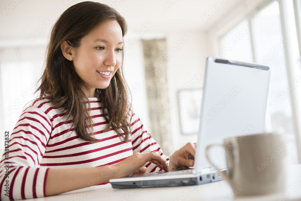 Mixed race woman using laptop Mixed race woman using laptop