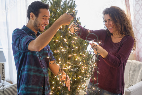 Couple decorating Christmas tree