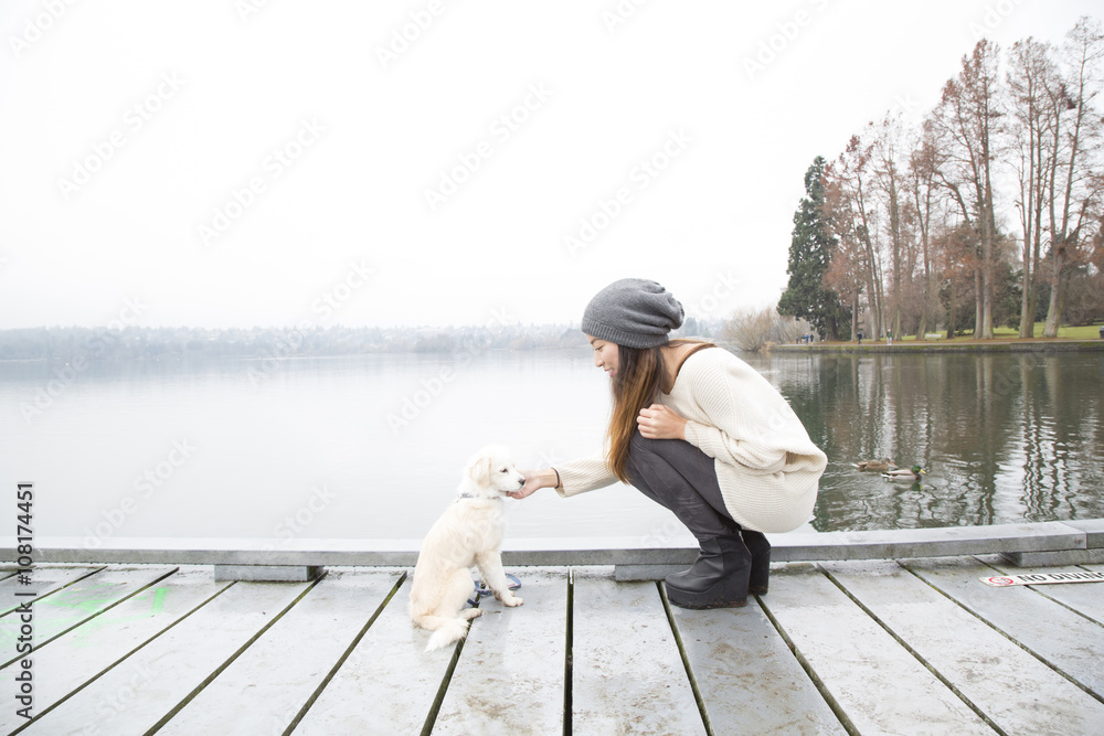 Woman petting dog at pier Woman petting dog at pier