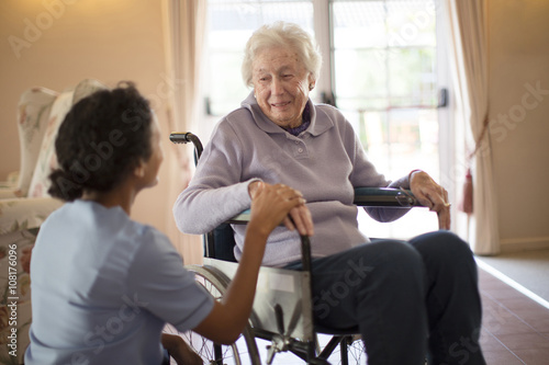 Nurse talking to patient in wheelchair photo