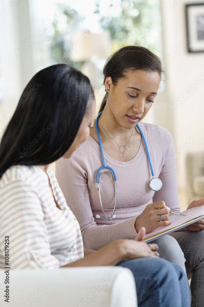 Doctor and patient talking in living room Doctor and patient talking in living room