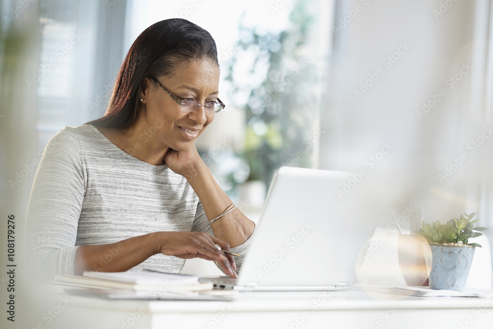 Senior woman using a laptop while sitting at home Senior woman using a laptop while sitting at home