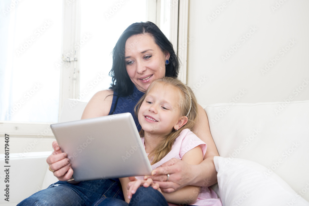 young attractive woman and sweet little blond child holding digital tablet pad watching internet together young attractive woman and sweet little blond child holding digital tablet pad watching internet together