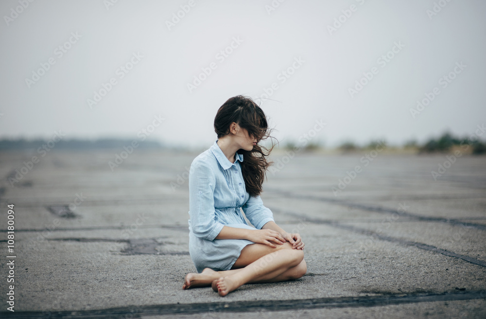 Caucasian woman sitting on concrete Caucasian woman sitting on concrete