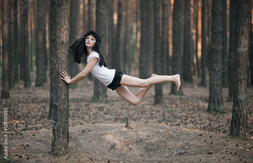 Caucasian woman floating in forest