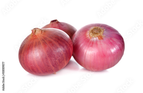 unpeeled whole red onion, shallots on white background
