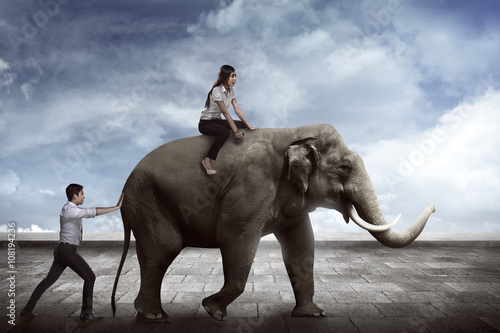 Asian business man push elephant