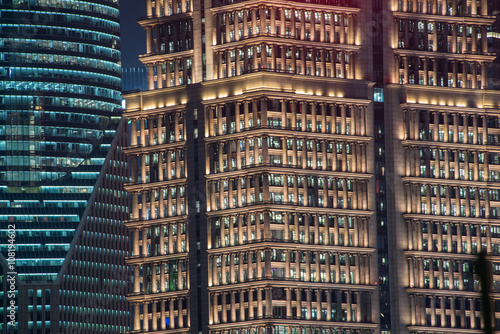 Ausschnitt einer illuminierten Hochhausfassade mit vielen Fenstern