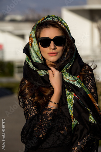 beautiful brunette girl in a headscarf and sunglasses. Stylish and luxury model