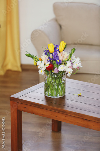 A bouquet of fresh flowers on wooden table, close up