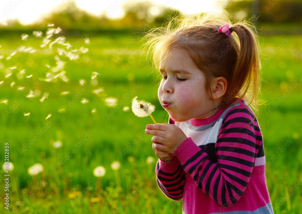 Girl blowing dandelion