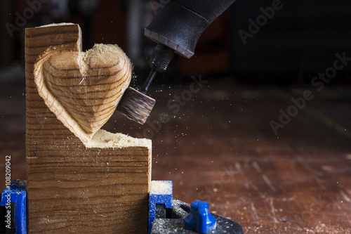 sanding wood in heart shape with a rotary tool photo
