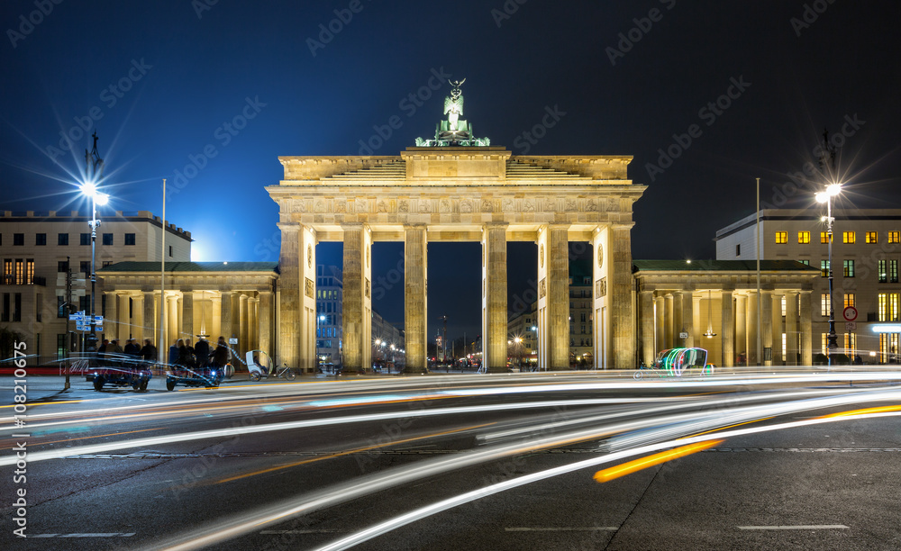 Brandenburger Tor in Berlin bei Nacht mit weißen Verkehrslichtern