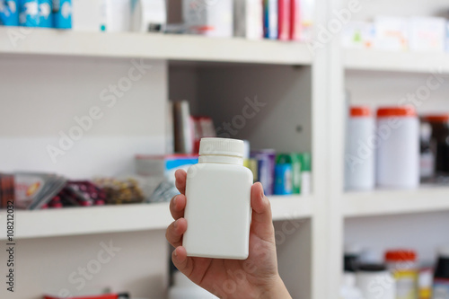 hand hold medicine bottle in the pharmacy
