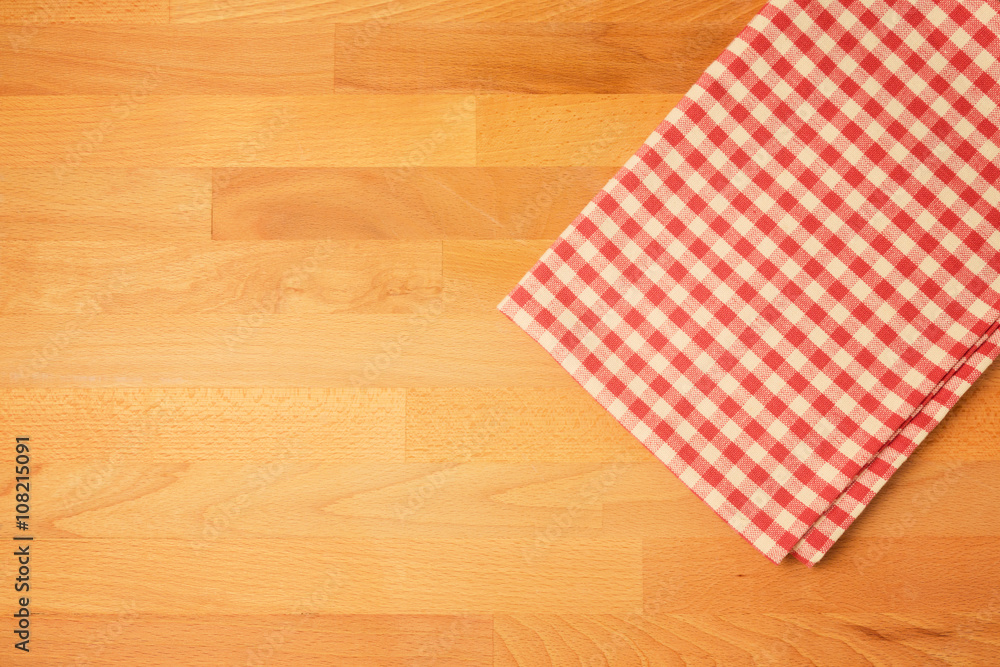 Checked tablecloth on wooden kitchen counter. View from above