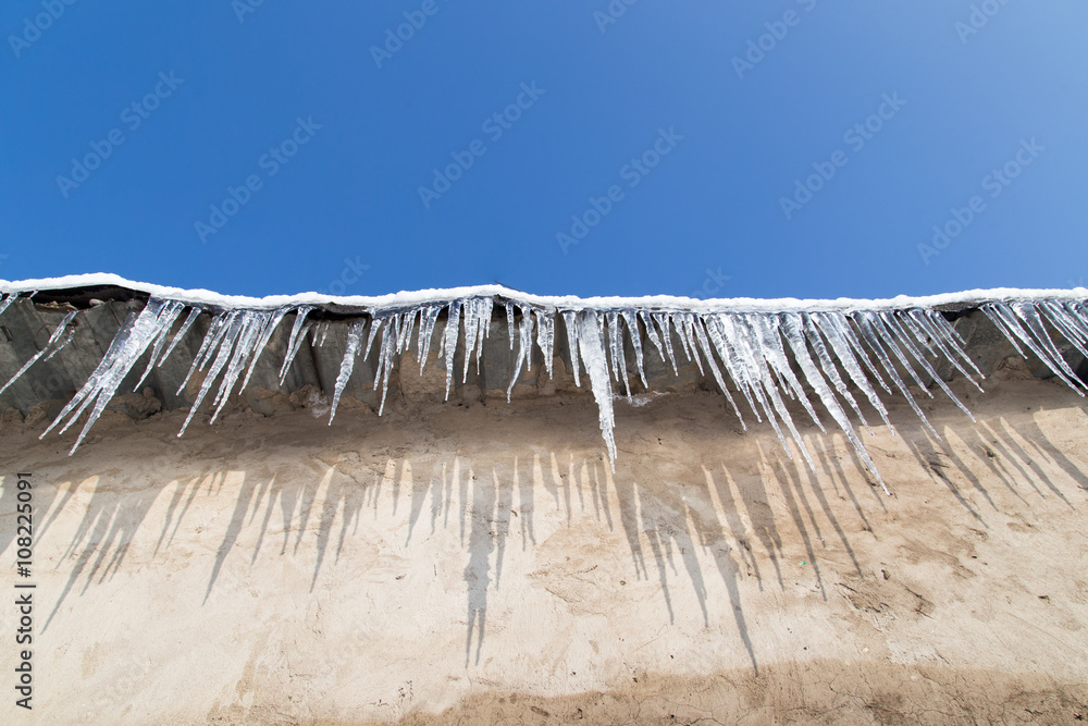 icicles on a roof of a house in winter icicles on a roof of a house in winter