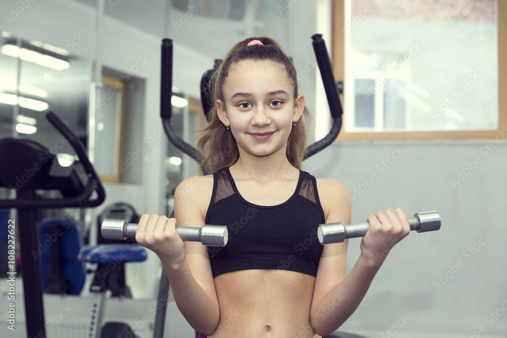 Girl is engaged in sports and gymnastics in the gym Girl is engaged in sports and gymnastics in the gym