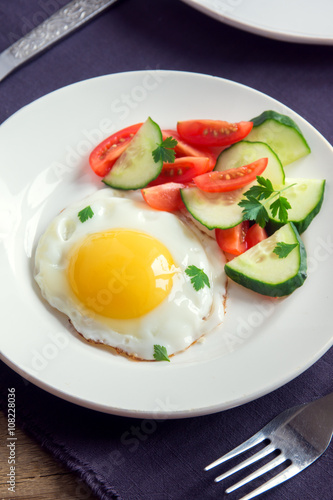 Fried egg with vegetable salad