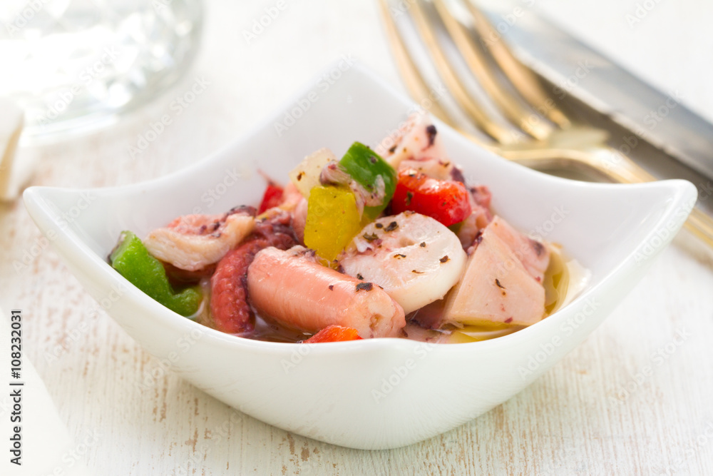 salad with octopus in bowl on white wooden background salad with octopus in bowl on white wooden background