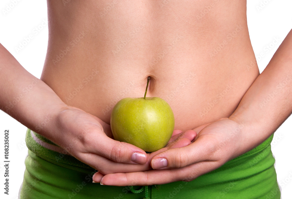 Sporty belly with apple in woman's hands Sporty belly with apple in woman's hands