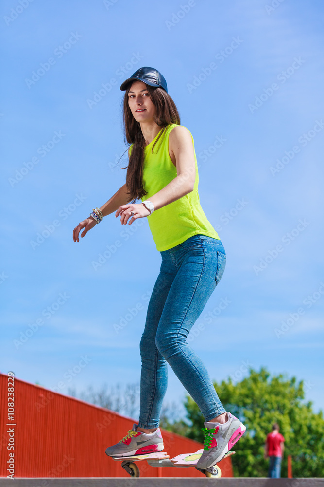Teen girl skater riding skateboard on street. Teen girl skater riding skateboard on street.
