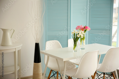 Beautiful tulips and irises on dinning table , indoors