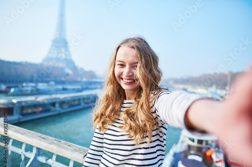 Fototapeta Naklejka Na Ścianę i Meble -  Young girl taking selfie near the Eiffel tower