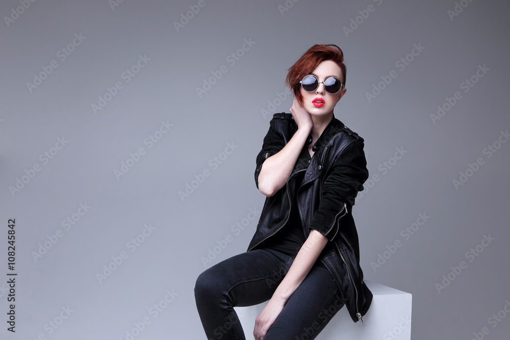 Redhead fashion model in sunglasses and black leather jacket Redhead fashion model in sunglasses and black leather jacket