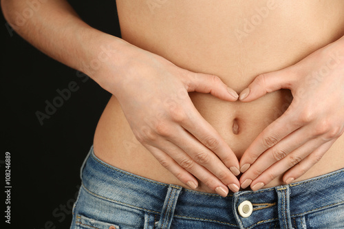 Canvas Print Hands forming heart on female belly button