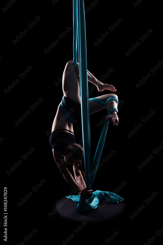 Fototapeta Young woman gymnast with blue gymnastic aerial silks