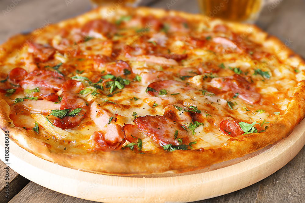 Delicious pizza  and glasses of beer are on wooden table, close up