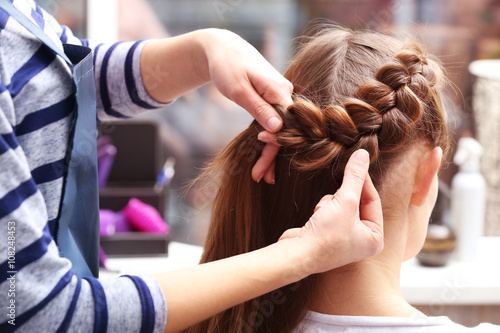 Professional hairdresser braiding clients hair
