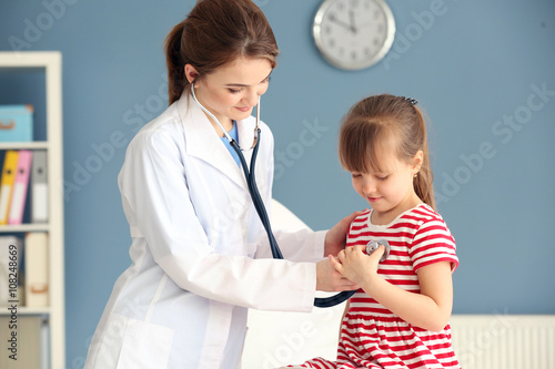 Doctor examining girl with ...