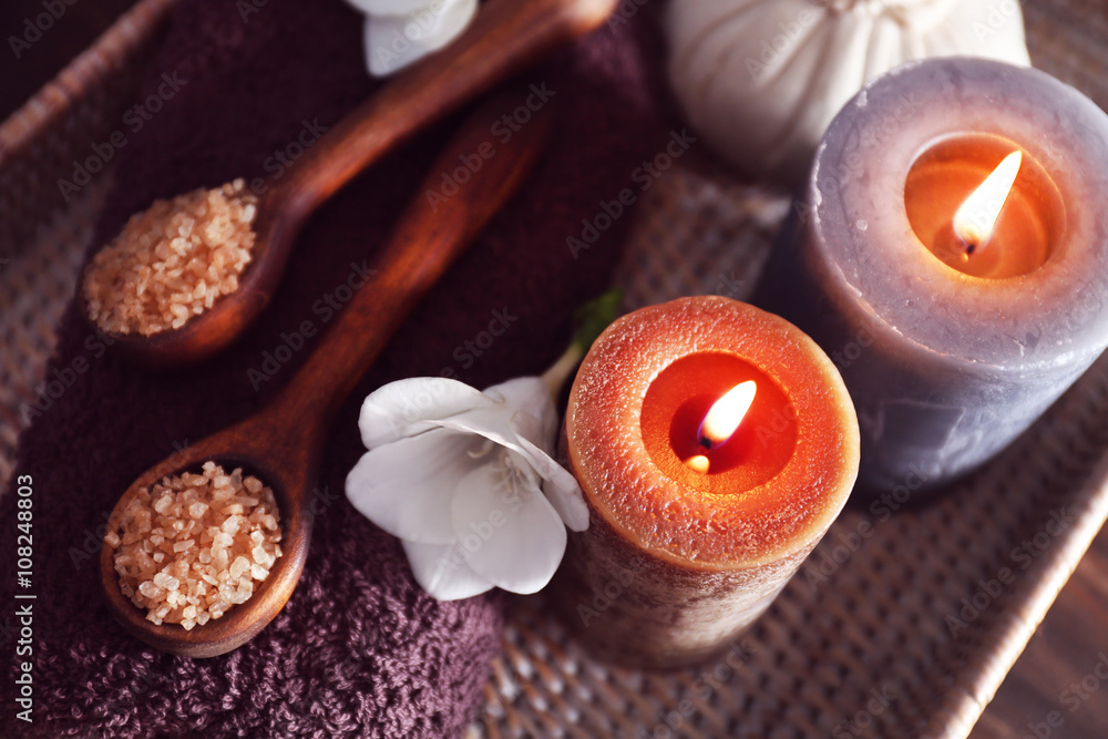Spa set with sea salt, exotic flowers and candles on wicker tray Spa set with sea salt, exotic flowers and candles on wicker tray