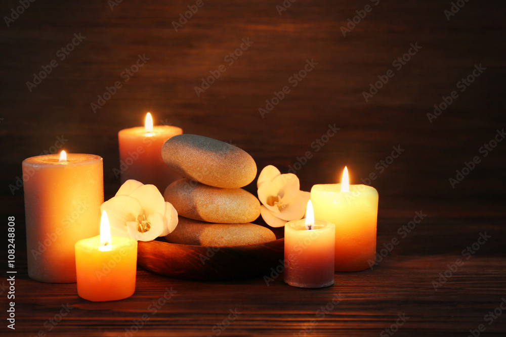 Spa composition with alight candles on wooden background in the dark Spa composition with alight candles on wooden background in the dark