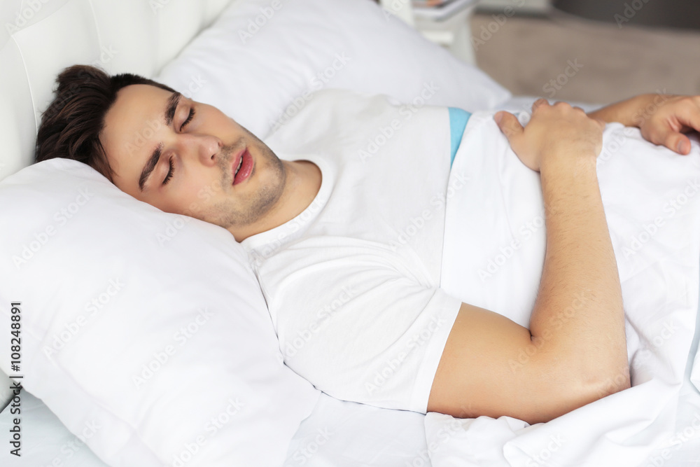 Young man sleeping on comfortable bed Young man sleeping on comfortable bed