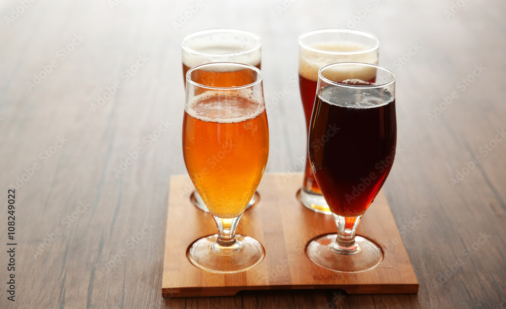 Glasses with different sorts of craft beer on wooden tray Glasses with different sorts of craft beer on wooden tray