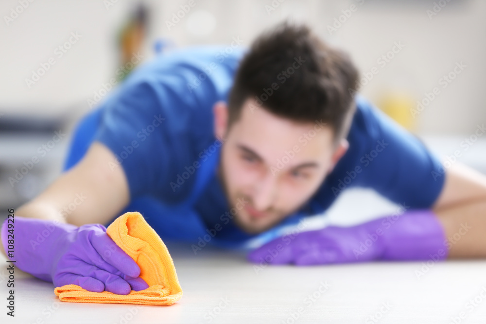 Man cleaning table in the kitchen Man cleaning table in the kitchen