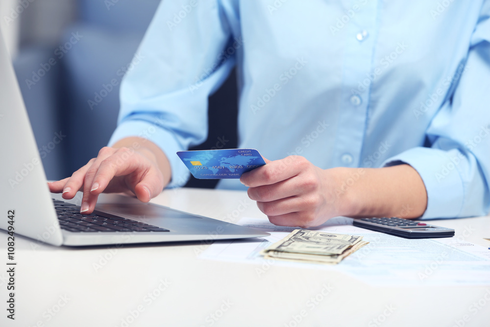 Fototapeta premium Woman counting money and making calculations