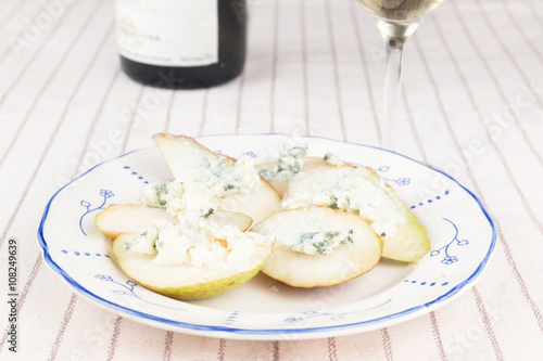 Blue cheese on pear wedges with glass of white wine