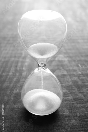 Sand hourglass on wooden background