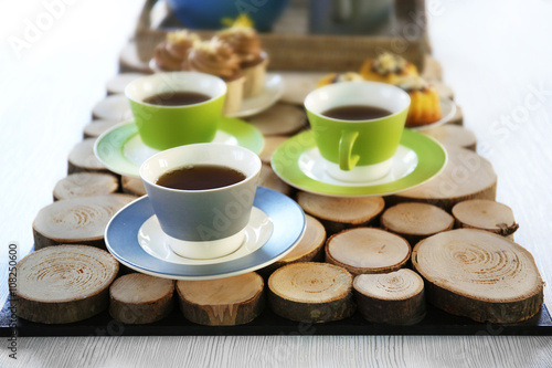 Table setting with tea and cakes on wooden background